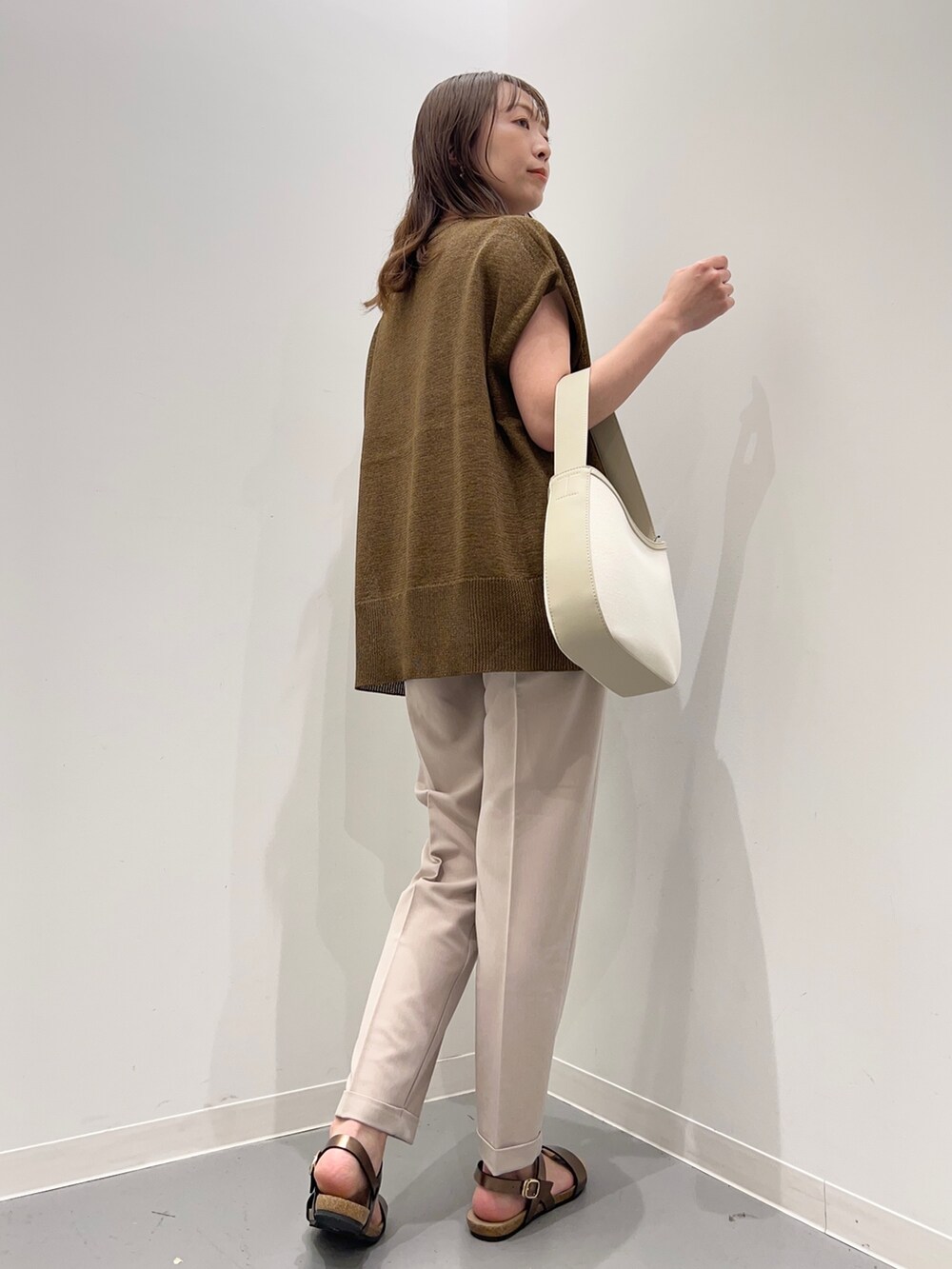 イエロー系のトップス、ベージュ系のその他パンツ、ブラウン系のサンダルを着用したレディースの夏コーディネートの4枚目の写真