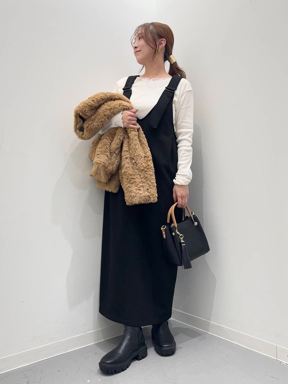 ブラック系のトートバッグ、ブラック系のブーツ、イエロー系のその他アウターを着用したレディースの冬コーディネートの7枚目の写真