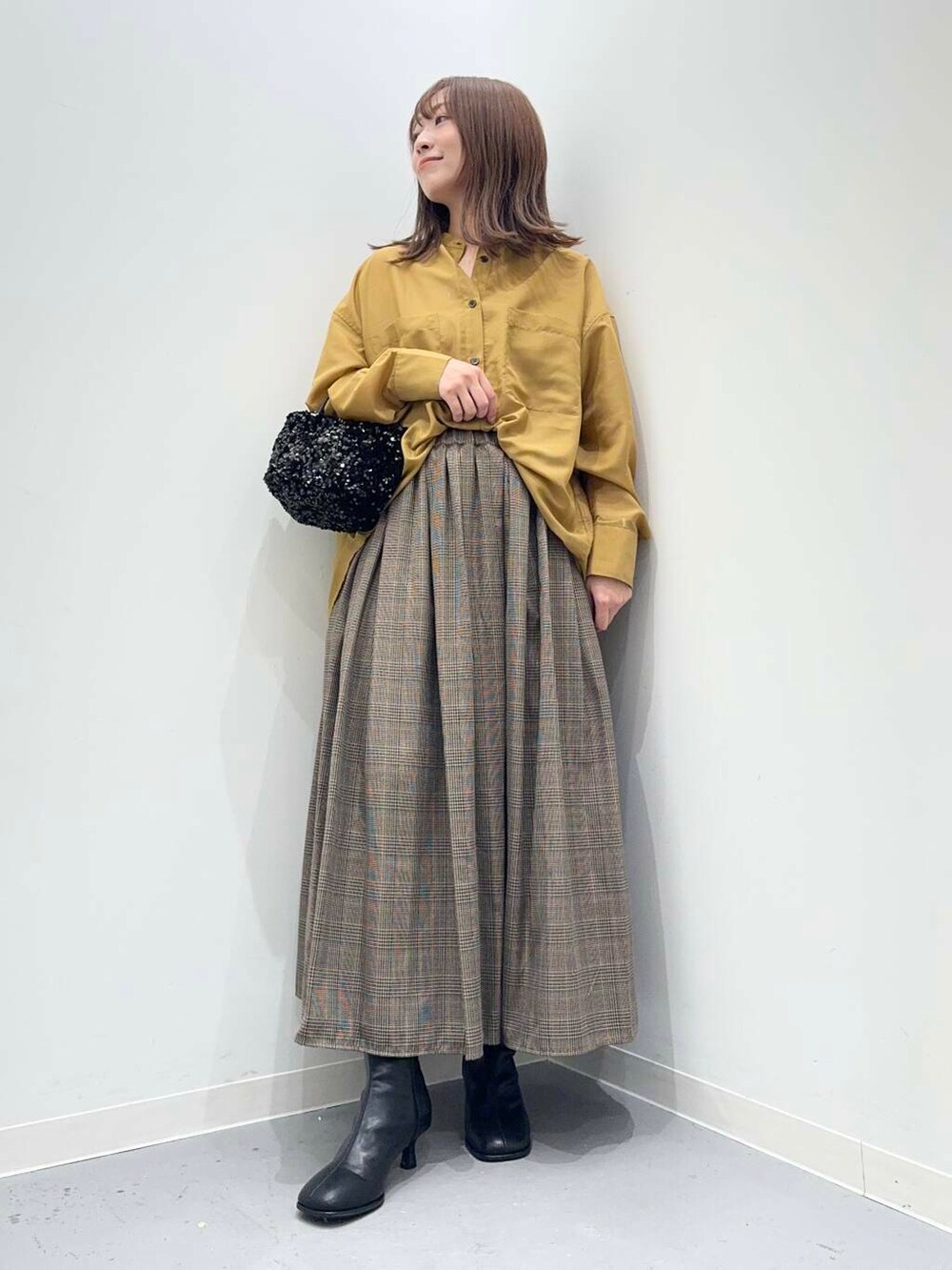 ブラック系のショルダーバッグ、イエロー系のシャツ/ブラウス、その他のスカートを着用したレディースの秋コーディネートの2枚目の写真