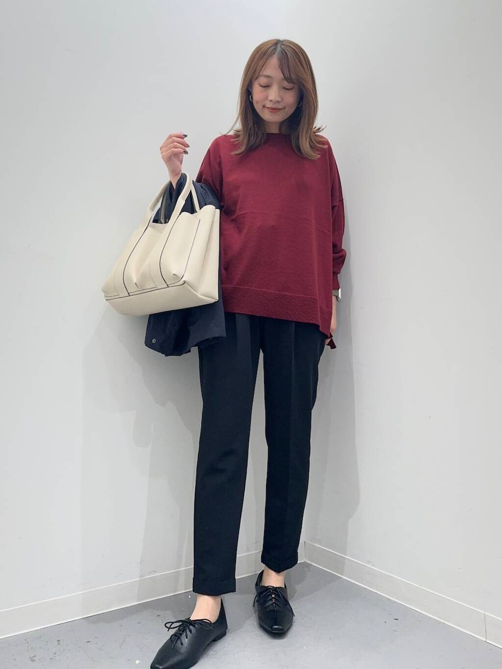ブラック系のトートバッグ、レッド系のニット/セーター、ブラック系のその他パンツを着用したレディースの秋コーディネートの5枚目の写真