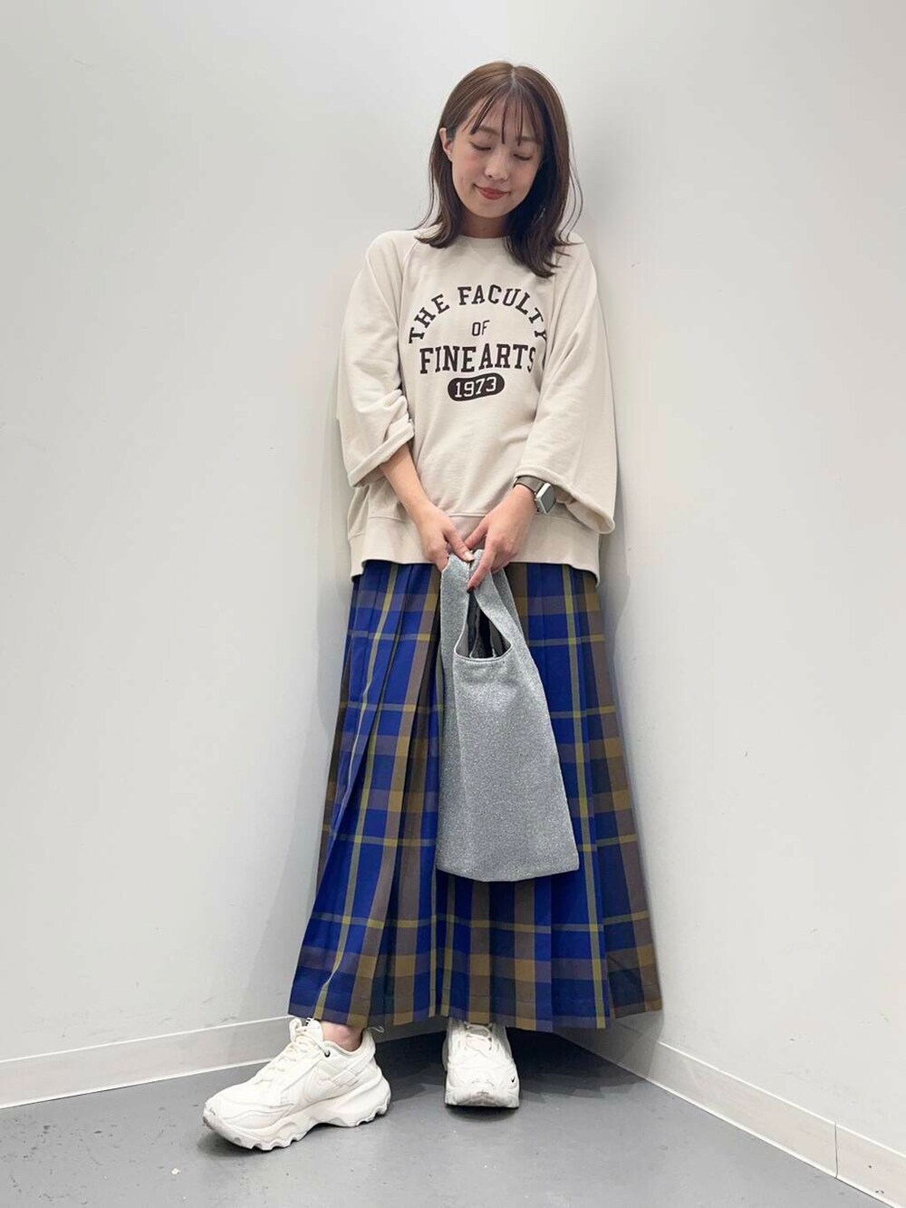 ベージュ系のTシャツ/カットソー、ブルー系のスカートを着用したレディースの秋コーディネートの4枚目の写真