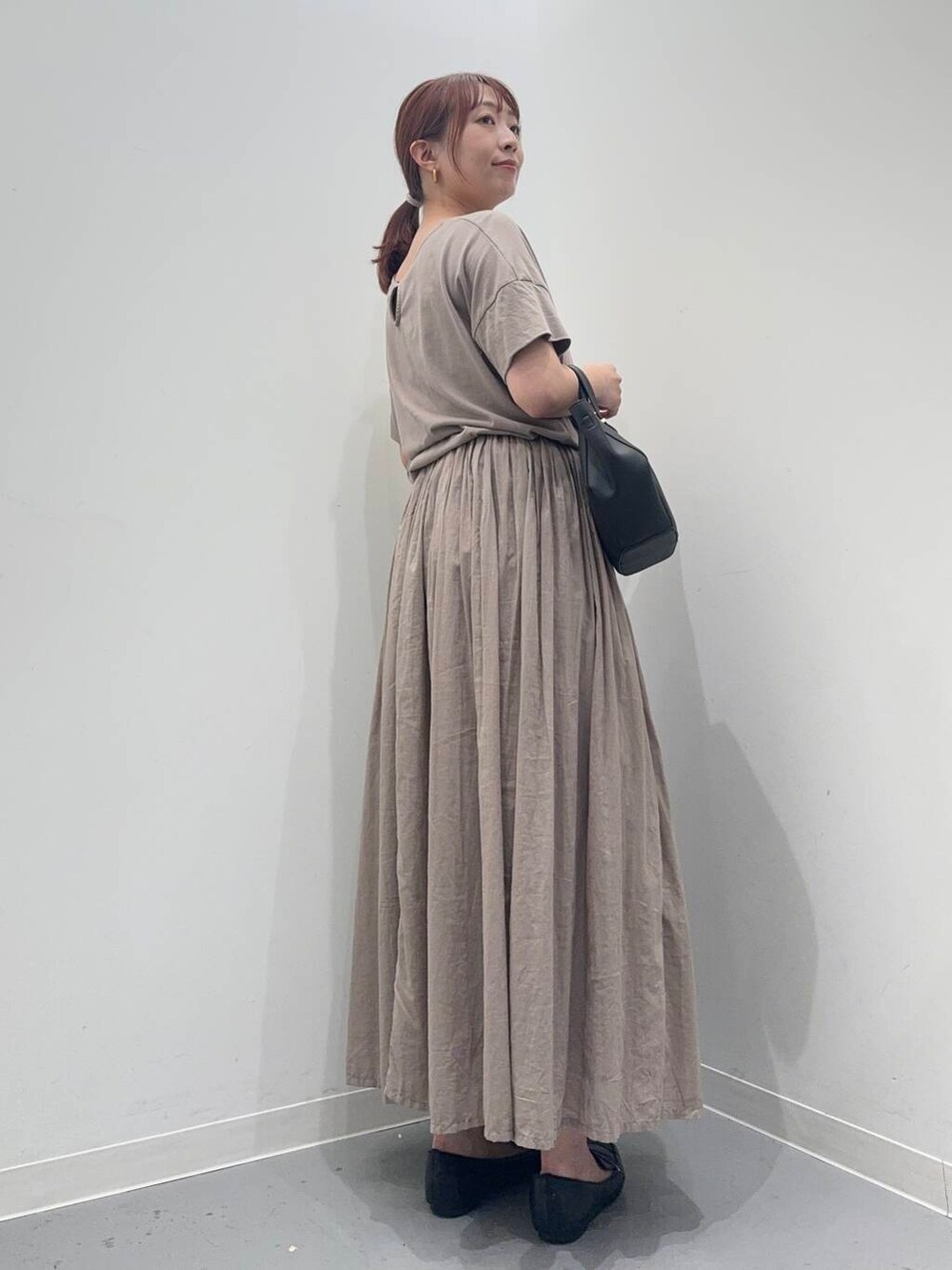 ブラック系のローファー、グレー系のワンピース、ブラック系のショルダーバッグを着用したレディースの夏コーディネートの4枚目の写真