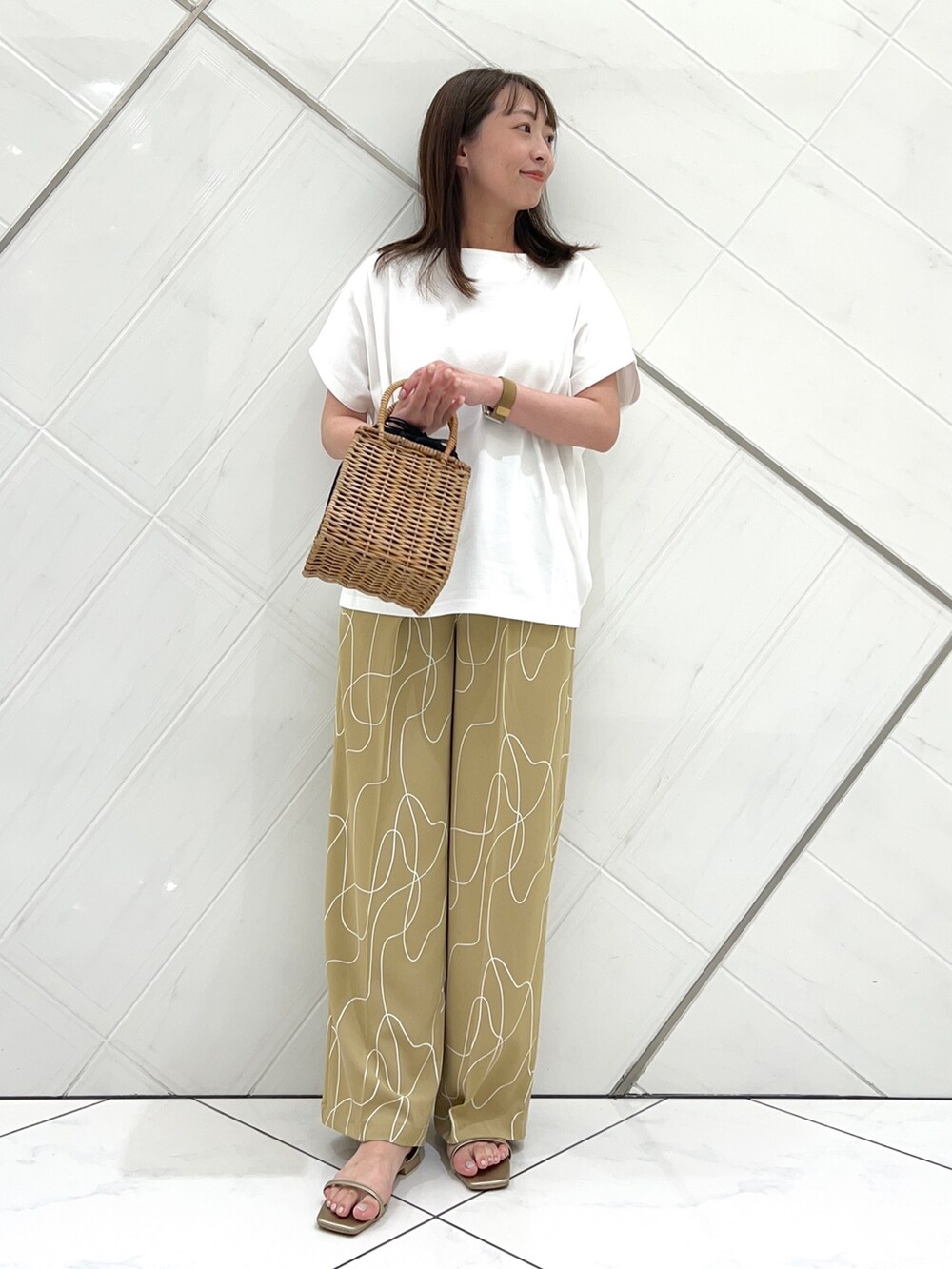 ホワイト系のTシャツ/カットソー、ベージュ系のその他パンツ、ゴールド系のサンダルを着用したレディースの夏コーディネートの2枚目の写真