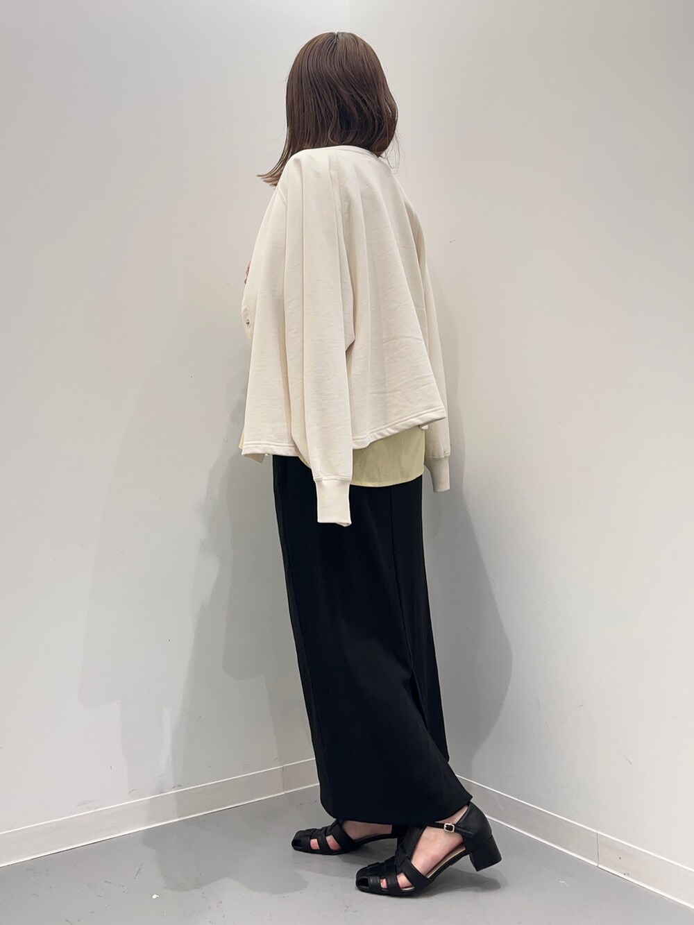 イエロー系のシャツ/ブラウス、ブラック系のスカート、ホワイト系のカーディガン/ボレロを着用したレディースの春コーディネートの4枚目の写真