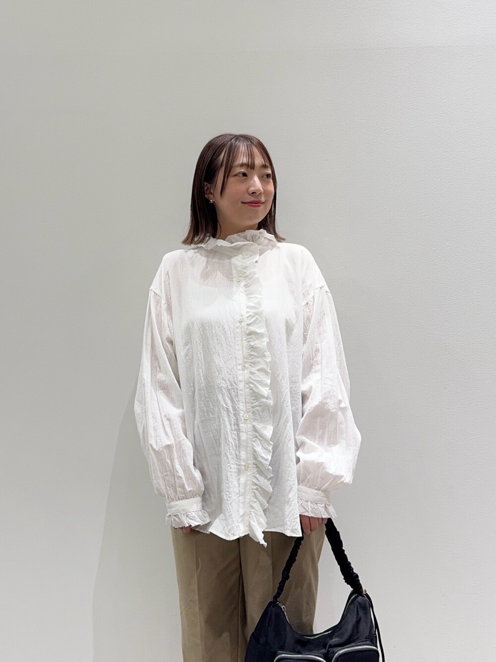 ホワイト系のシャツ/ブラウス、ベージュ系のその他パンツ、ブラック系のショルダーバッグを着用したレディースの秋コーディネートの5枚目の写真