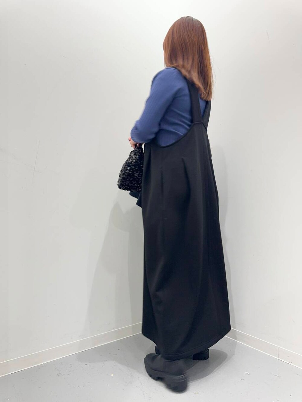 ブラック系のショルダーバッグ、ブラック系のブーツ、ブルー系のステンカラーコートを着用したレディースの冬コーディネートの7枚目の写真