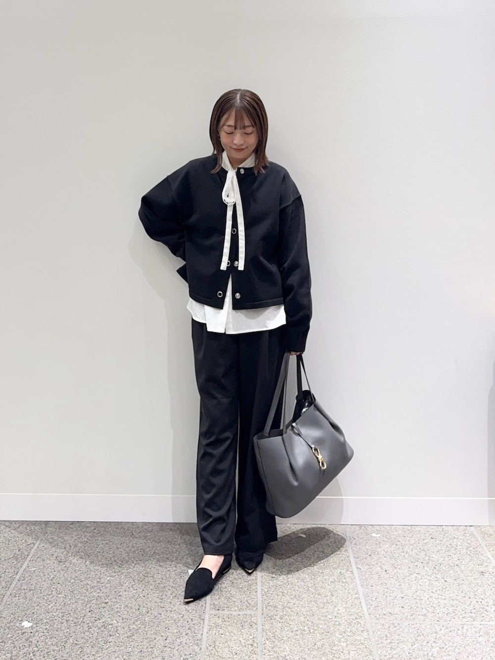 ブラック系のカーディガン/ボレロ、ホワイト系のシャツ/ブラウス、ブラック系のその他パンツを着用したレディースの秋コーディネートの6枚目の写真