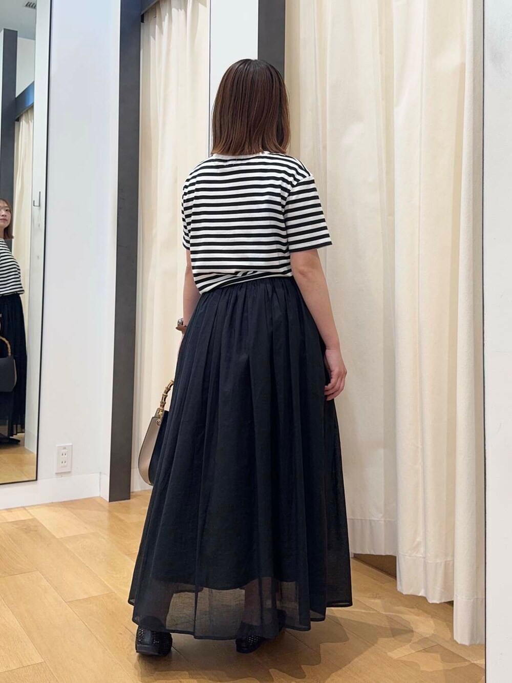 ブラック系のバレエシューズ、ブラック系のワンピース、ブラック系のハンドバッグを着用したレディースの夏コーディネートの5枚目の写真