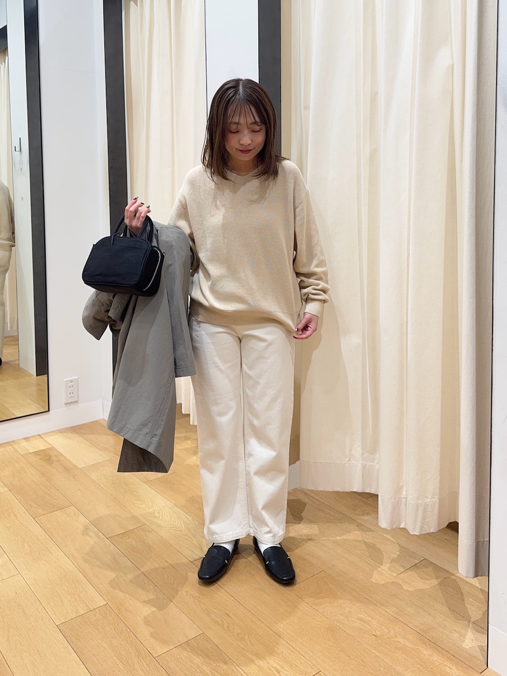 ブラウン系のその他アウター、ホワイト系のニット/セーター、ブラック系のボストンバッグを着用したレディースの冬コーディネートの5枚目の写真