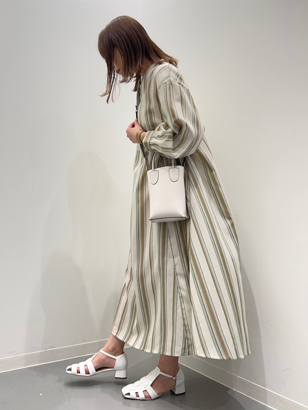 グリーン系のワンピース、ホワイト系のサンダルを着用したレディースの春コーディネートの4枚目の写真