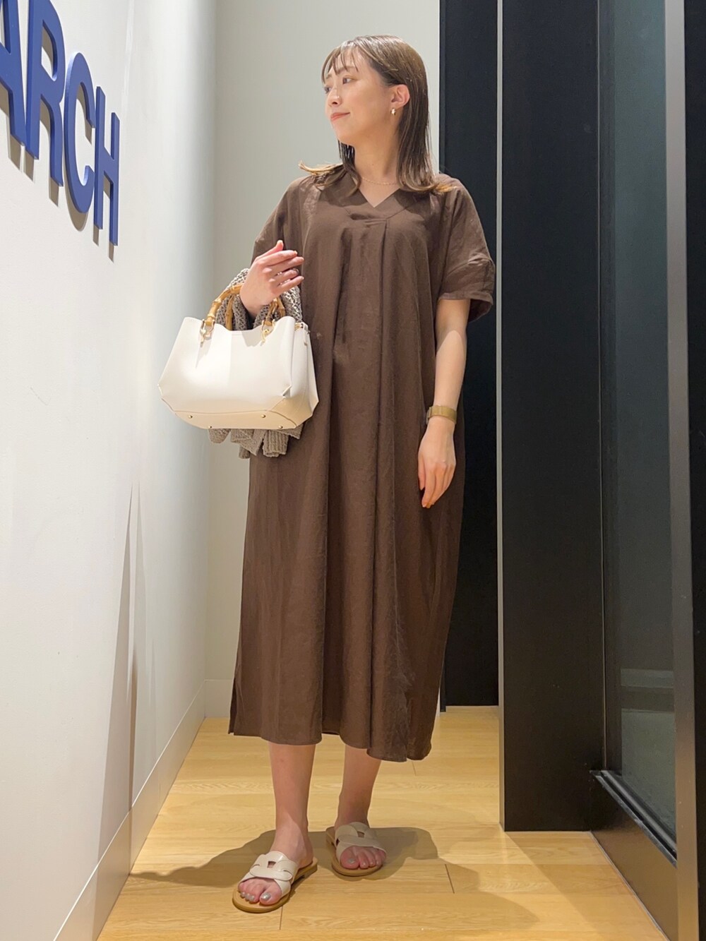 ブラウン系のワンピース、グリーン系のカーディガン/ボレロ、ホワイト系のサンダルを着用したレディースの夏コーディネートの5枚目の写真