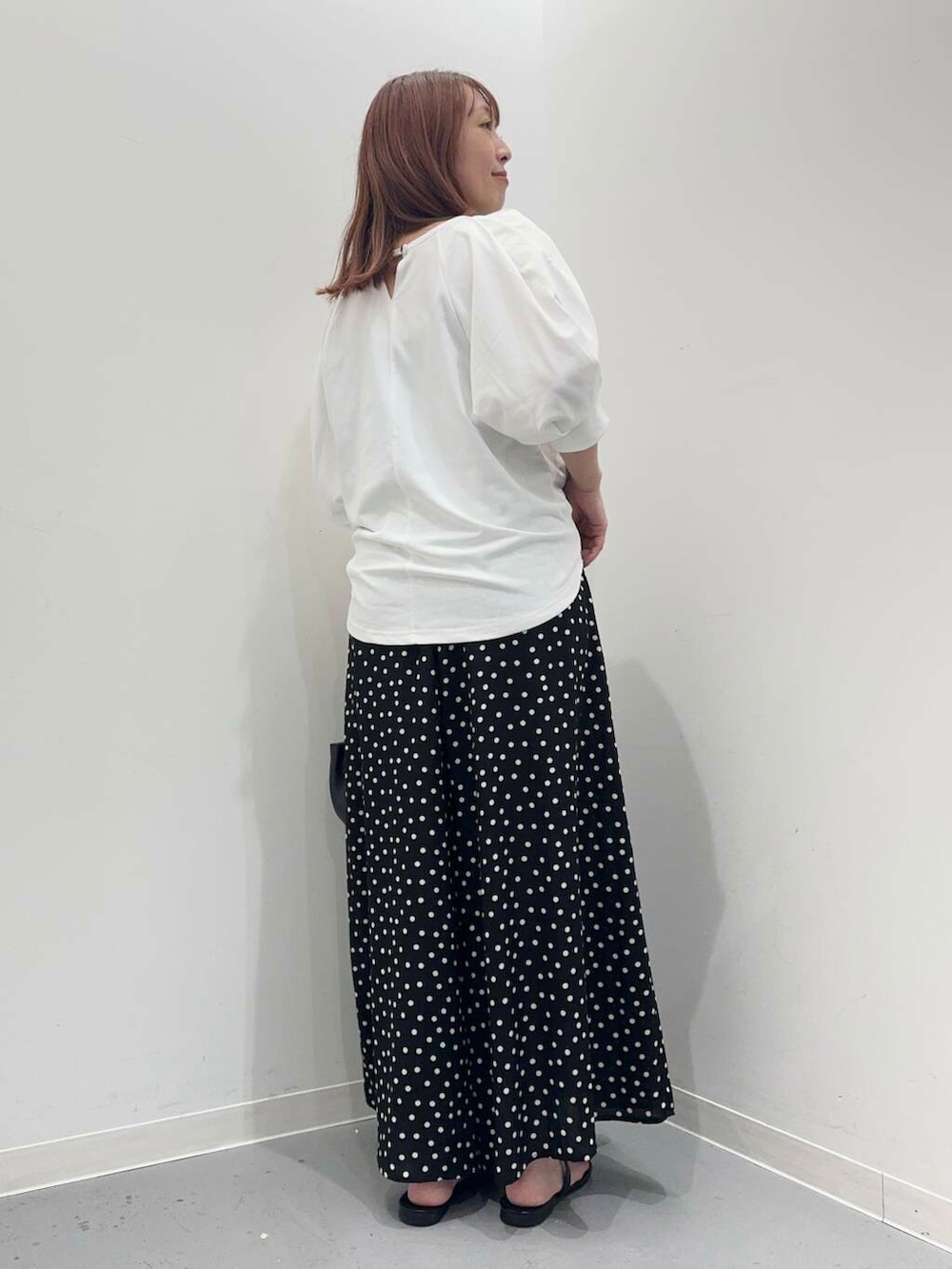 ホワイト系のTシャツ/カットソー、ブラック系のサンダル、ブラック系のショルダーバッグを着用したレディースの夏コーディネートの4枚目の写真