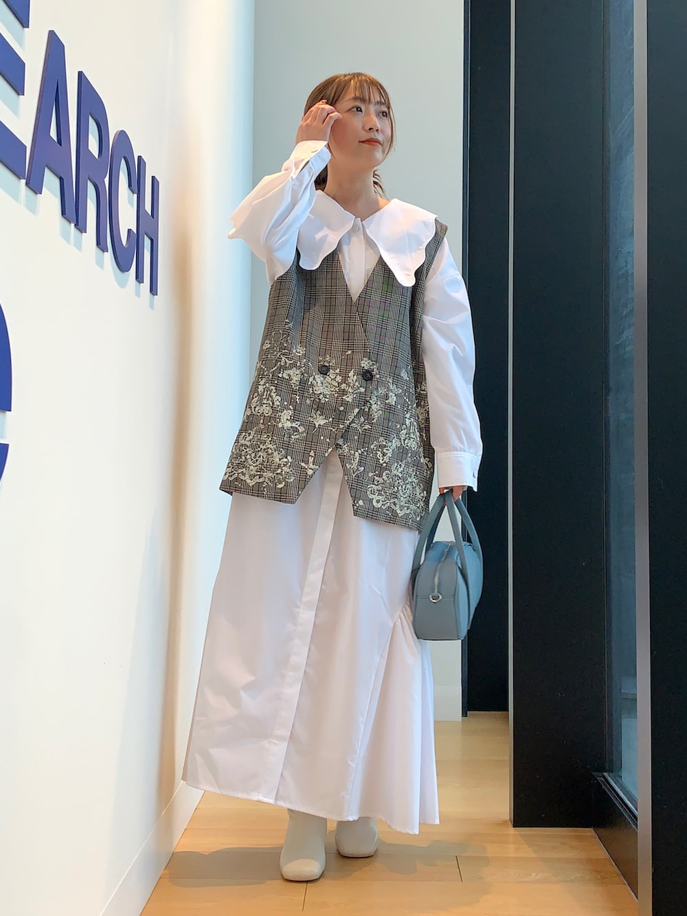 ブラウン系のベスト、ホワイト系のワンピースを着用したレディースの冬コーディネートの5枚目の写真