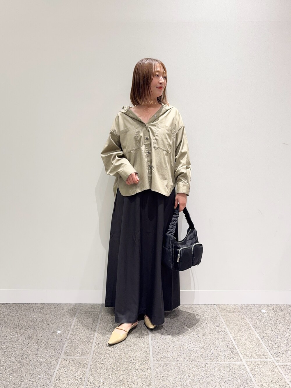 ベージュ系のシャツ/ブラウス、グレー系のスカート、ベージュ系のパンプスを着用したレディースの秋コーディネートの2枚目の写真