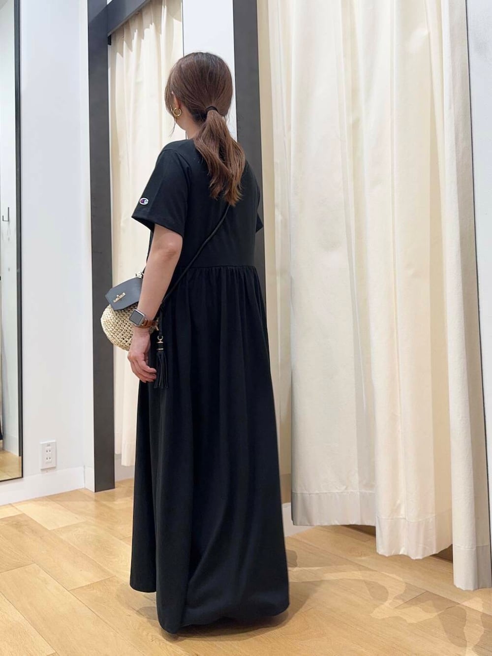 ベージュ系のショルダーバッグ、ブラック系のワンピース、ブラック系のサンダルを着用したレディースの春コーディネートの3枚目の写真