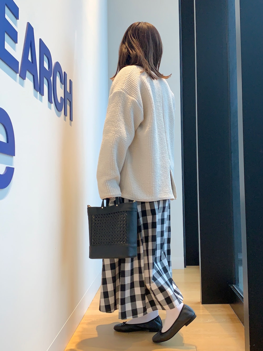 パープル系のニット/セーター、その他のスカート、ホワイト系のノーカラージャケットを着用したレディースの春コーディネートの2枚目の写真