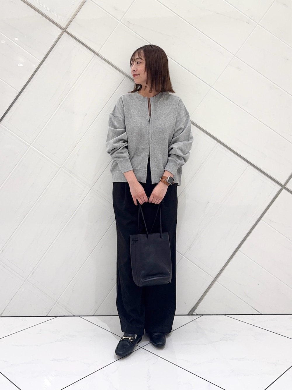 グレー系のカーディガン/ボレロ、ブラック系のその他パンツ、ブラック系のショルダーバッグを着用したレディースの秋コーディネートの2枚目の写真