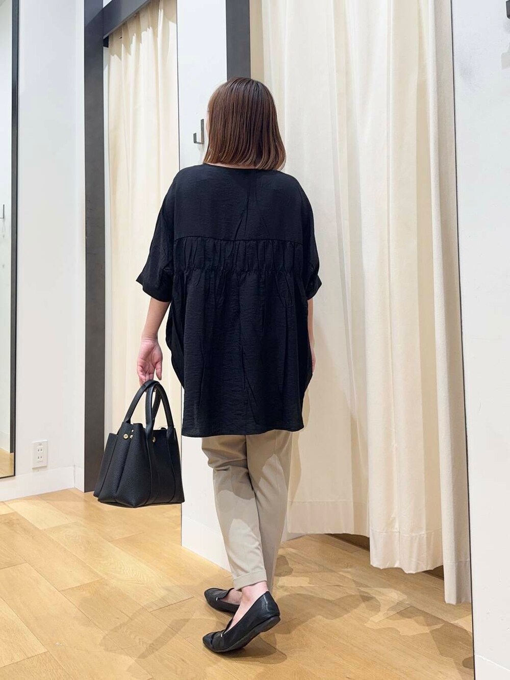 ブラック系のトートバッグ、ベージュ系のその他パンツ、ブラック系のシャツ/ブラウスを着用したレディースの夏コーディネートの5枚目の写真