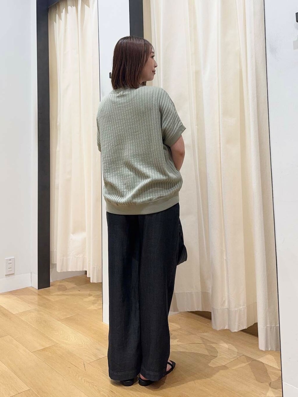 ブラック系のショルダーバッグ、ブラック系のデニムパンツ、グリーン系のTシャツ/カットソーを着用したレディースの夏コーディネートの3枚目の写真