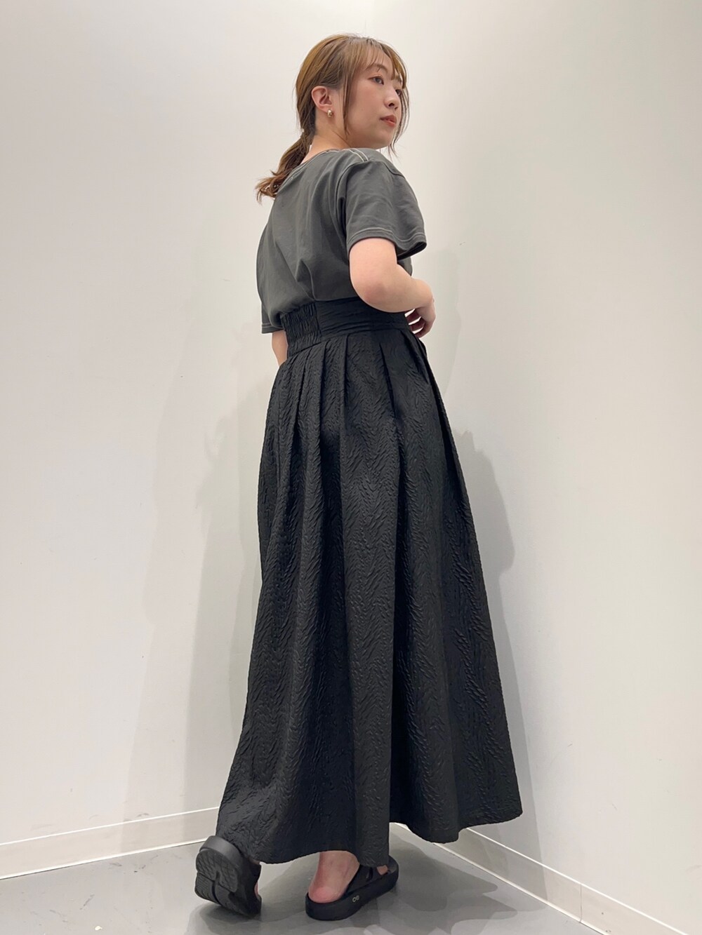 グレー系のTシャツ/カットソー、ブラック系のスカートを着用したレディースの春コーディネートの4枚目の写真