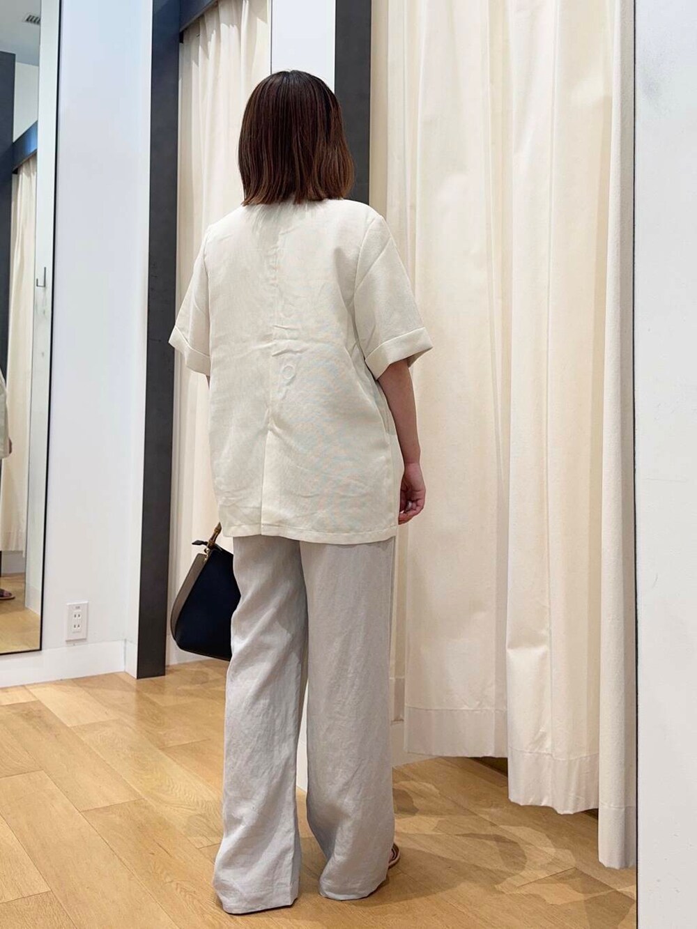 ブラウン系のサンダル、ベージュ系のその他パンツ、ブラック系のハンドバッグを着用したレディースの夏コーディネートの4枚目の写真