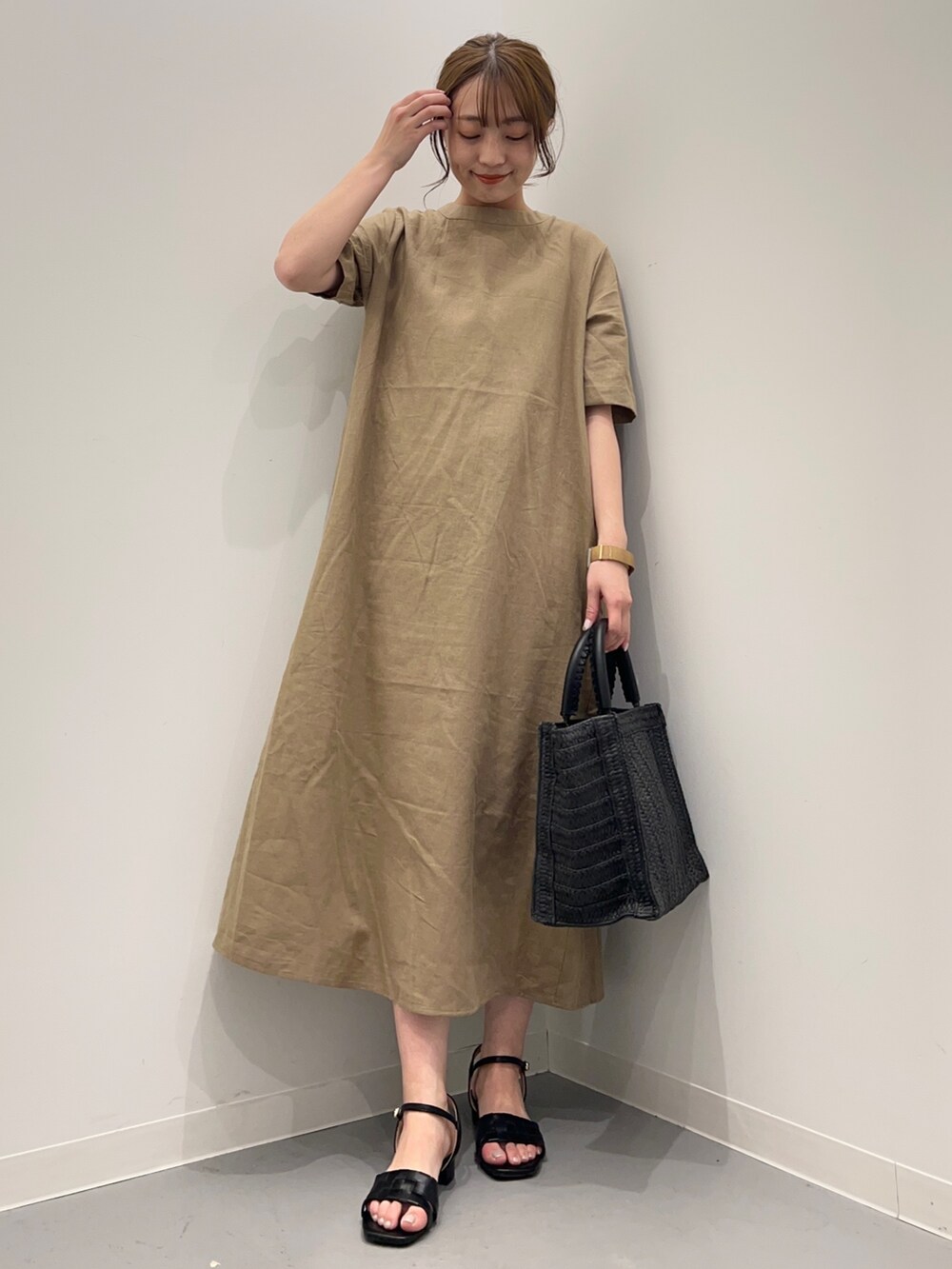 ベージュ系のワンピース、ブラック系のサンダルを着用したレディースの春コーディネートの2枚目の写真