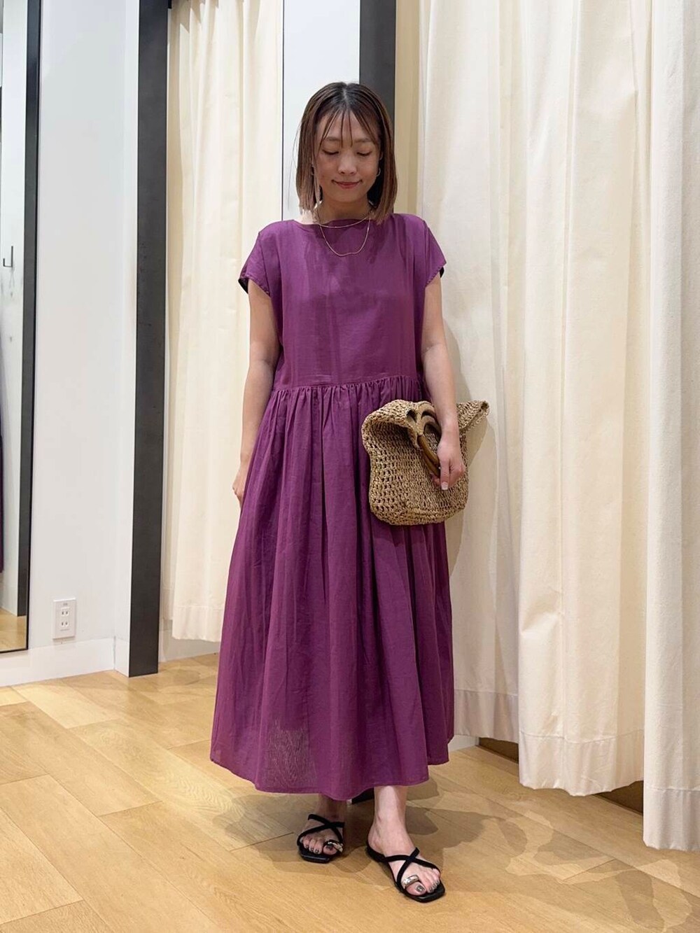 ベージュ系のトートバッグ、グレー系のワンピース、ブラック系のサンダルを着用したレディースの夏コーディネートの2枚目の写真