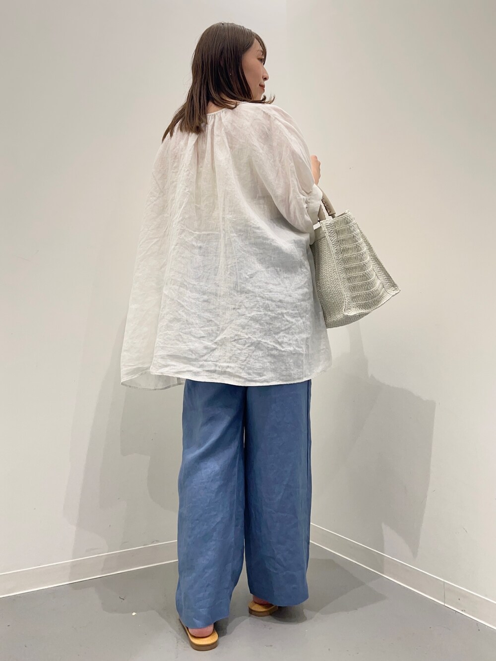 ホワイト系のシャツ/ブラウス、ブルー系のその他パンツ、ベージュ系のトートバッグを着用したレディースの夏コーディネートの4枚目の写真