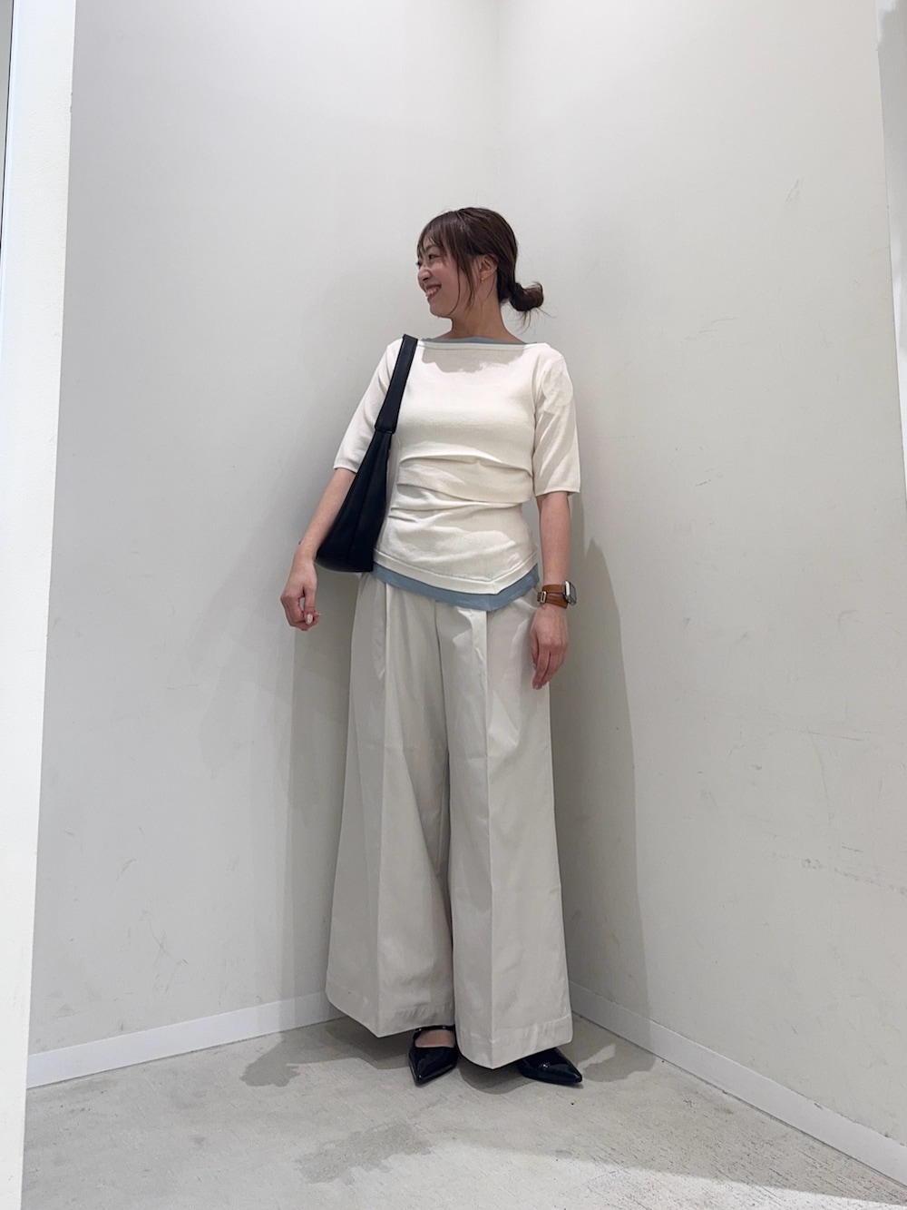 ホワイト系のニット/セーター、ホワイト系のチノパンツ、ブラック系のハンドバッグを着用したレディースの春コーディネートの2枚目の写真