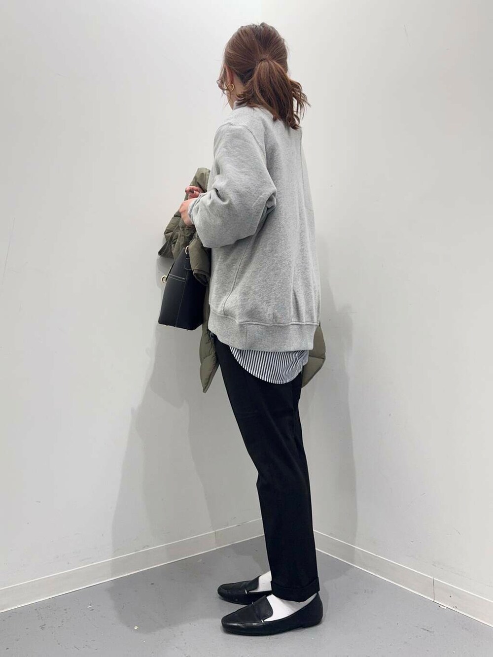 ブラック系のローファー、グリーン系のダウンジャケット/コート、ブルー系のシャツ/ブラウスを着用したレディースの冬コーディネートの7枚目の写真