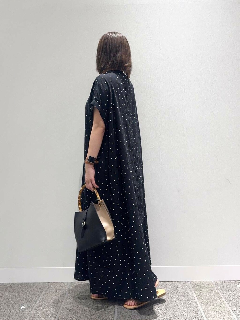 ブラウン系のサンダル、ブラック系のハンドバッグ、ブラック系のワンピースを着用したレディースの夏コーディネートの3枚目の写真