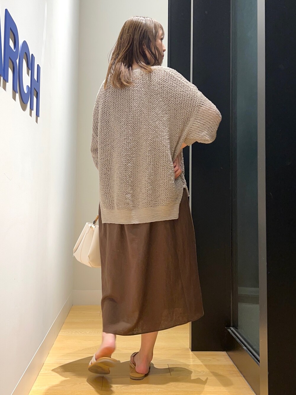 ブラウン系のワンピース、グリーン系のカーディガン/ボレロ、ホワイト系のサンダルを着用したレディースの夏コーディネートの2枚目の写真