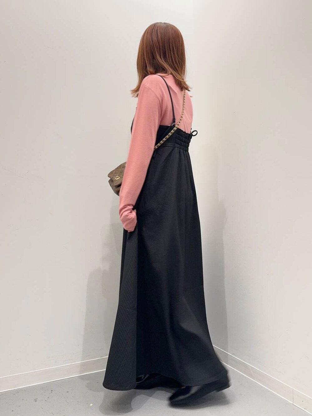 ブラウン系のショルダーバッグ、ピンク系のTシャツ/カットソー、ブラック系のワンピースを着用したレディースの夏コーディネートの3枚目の写真