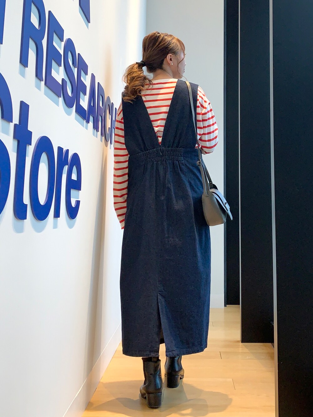 ブルー系のワンピース、レッド系のTシャツ/カットソー、ブラック系のブーツを着用したレディースの冬コーディネートの4枚目の写真