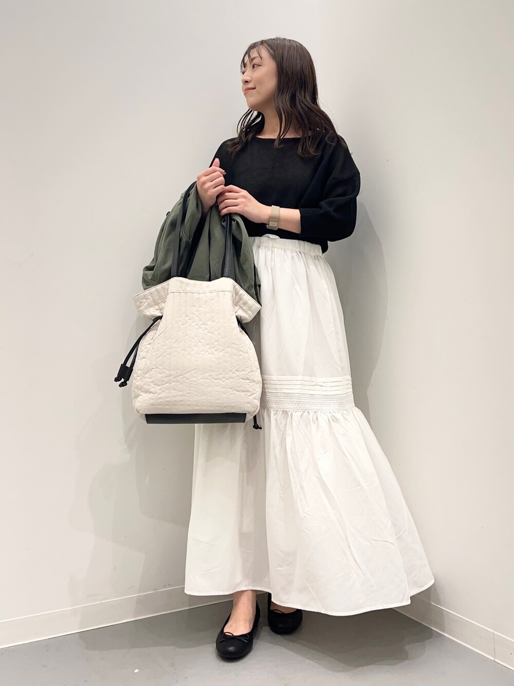 グリーン系のジャケット/アウター、ブラック系のニット/セーター、ホワイト系のスカートを着用したレディースの夏コーディネートの5枚目の写真