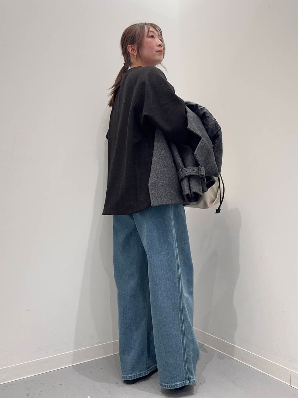 ブラック系のローファー、ホワイト系のショルダーバッグ、グレー系のトレンチコートを着用したレディースの冬コーディネートの7枚目の写真