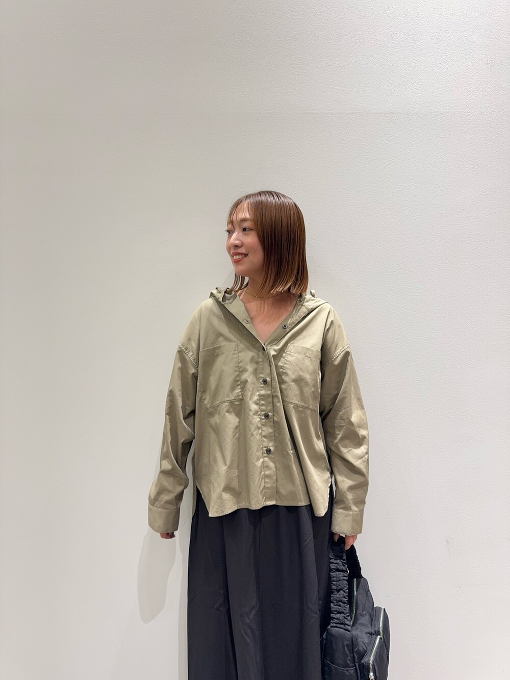 ベージュ系のシャツ/ブラウス、グレー系のスカート、ベージュ系のパンプスを着用したレディースの秋コーディネートの5枚目の写真