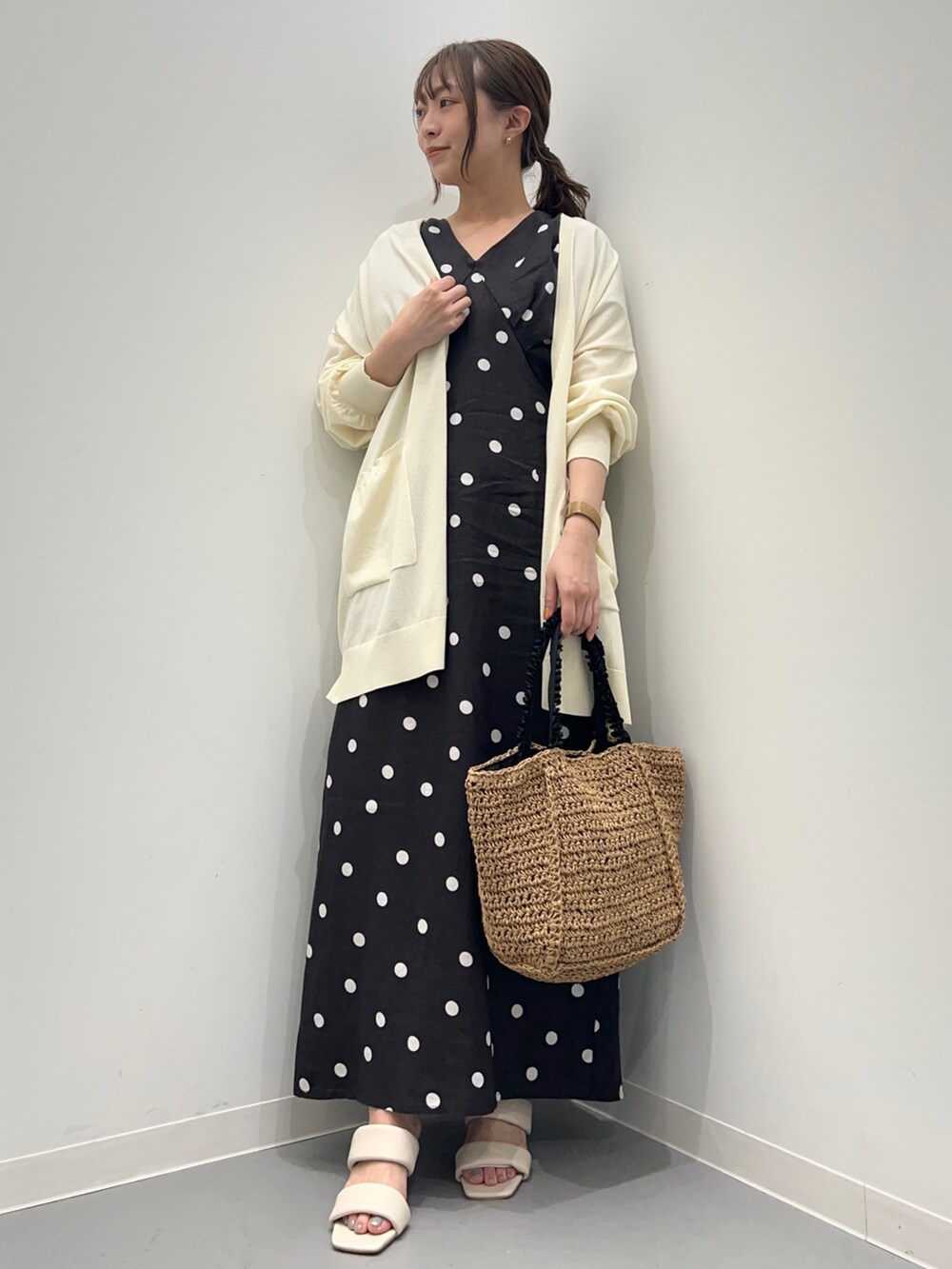 ブラック系のワンピース、ホワイト系のカーディガン/ボレロ、ベージュ系のかごバッグを着用したレディースの夏コーディネートの6枚目の写真
