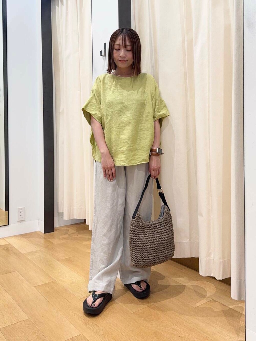 グレー系のトートバッグ、ブラック系のサンダル、イエロー系のシャツ/ブラウスを着用したレディースの夏コーディネートの5枚目の写真