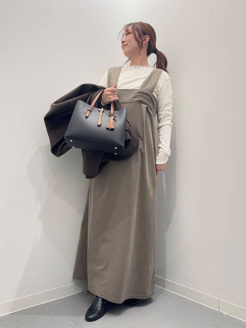 ブラック系のブーツ、ブラック系のトートバッグ、ブラウン系のその他アウターを着用したレディースの冬コーディネートの5枚目の写真