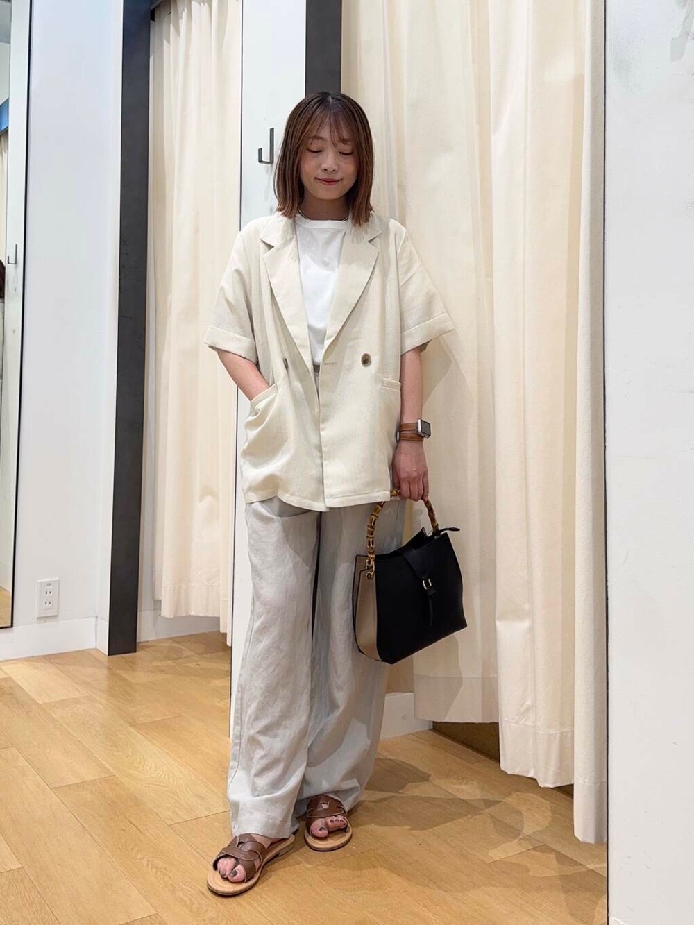 ブラウン系のサンダル、ベージュ系のその他パンツ、ブラック系のハンドバッグを着用したレディースの夏コーディネートの5枚目の写真