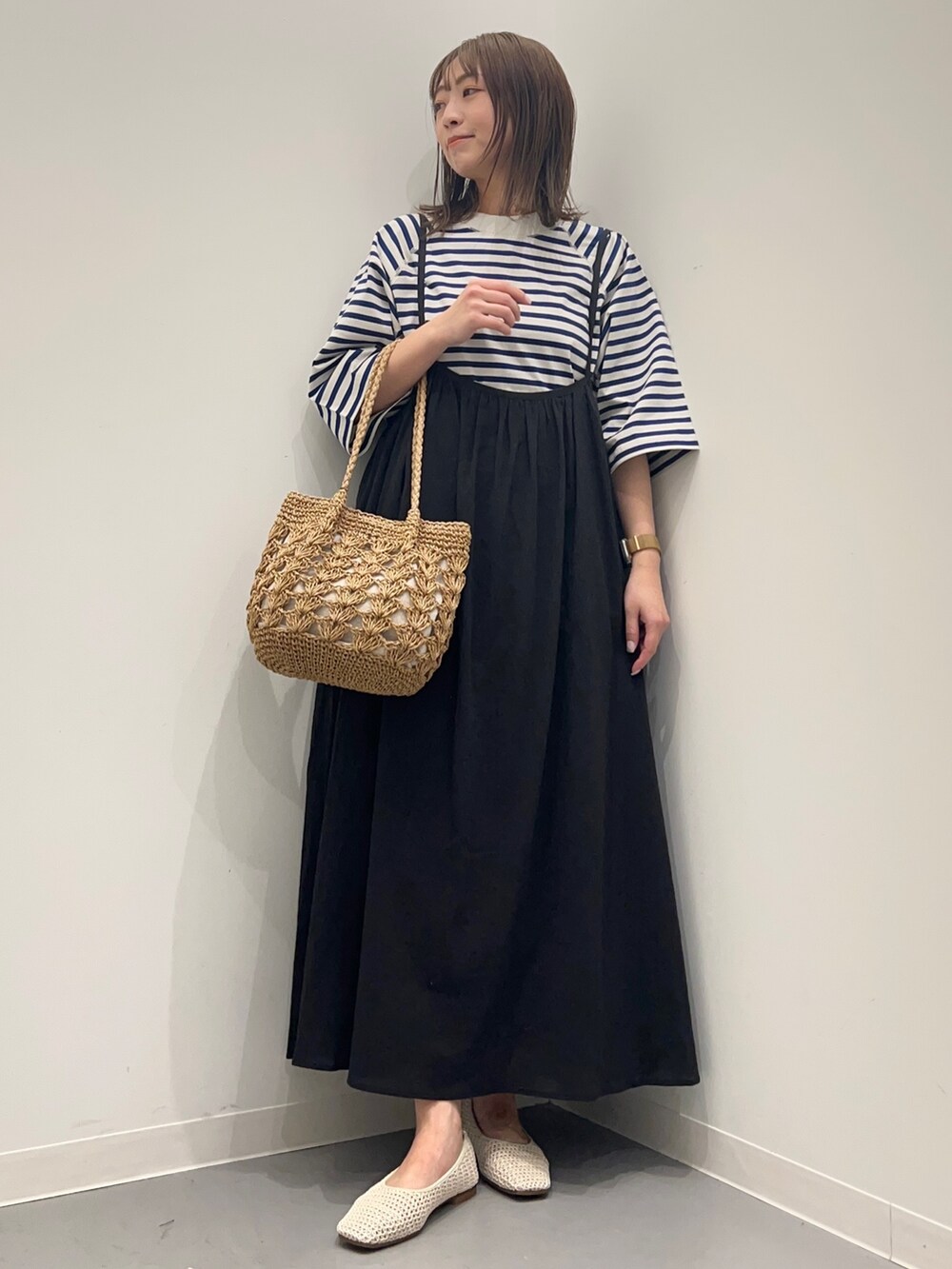 ホワイト系のTシャツ/カットソー、ブラック系のワンピースを着用したレディースの春コーディネートの2枚目の写真