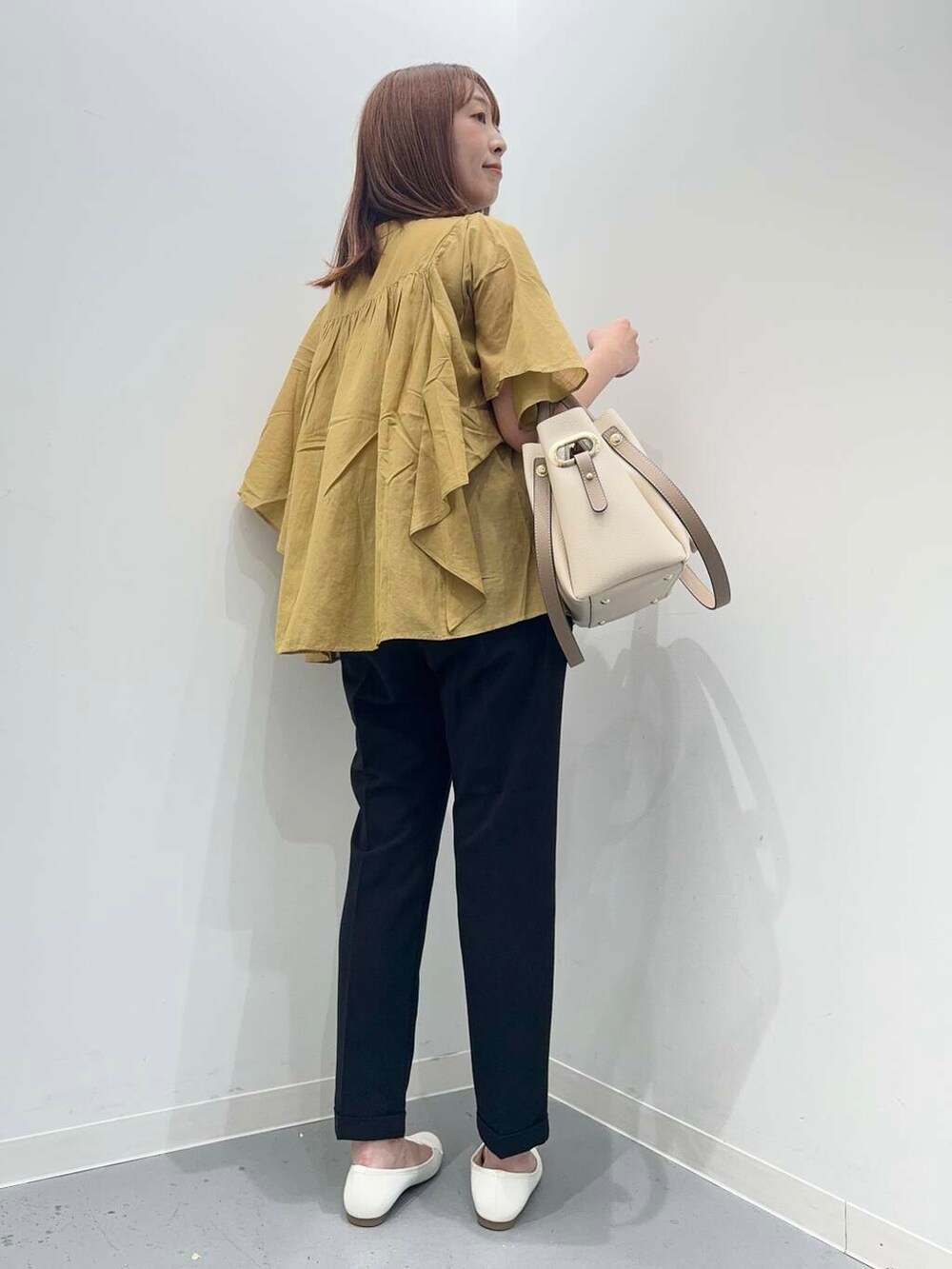 ホワイト系のトートバッグ、ホワイト系のバレエシューズ、イエロー系のシャツ/ブラウスを着用したレディースの夏コーディネートの4枚目の写真