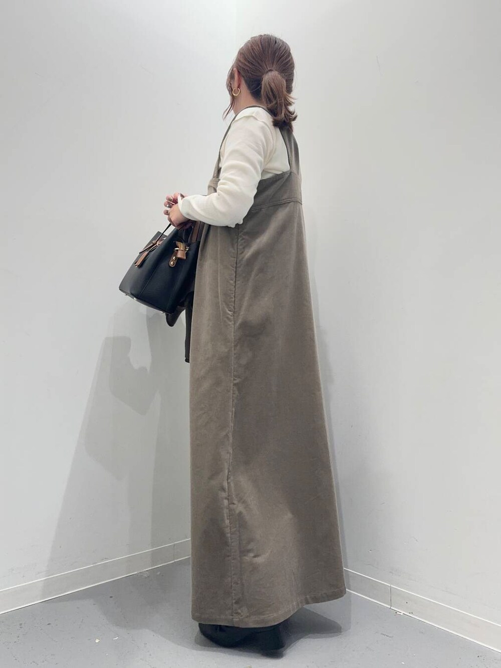 ブラック系のブーツ、ブラック系のトートバッグ、ブラウン系のその他アウターを着用したレディースの冬コーディネートの6枚目の写真