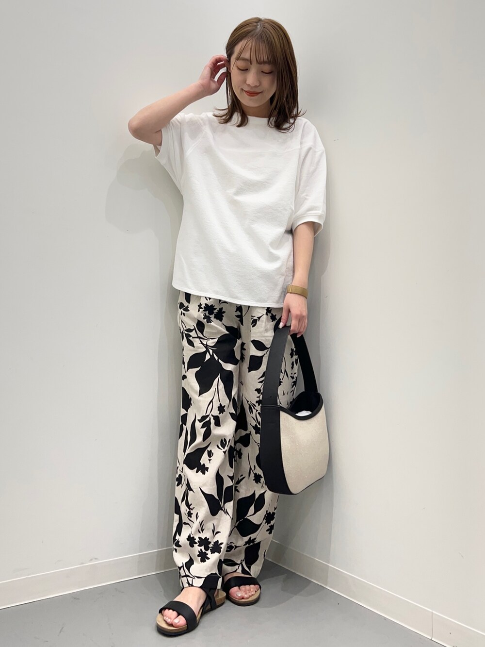 ホワイト系のTシャツ/カットソー、ベージュ系のその他パンツ、ブラック系のハンドバッグを着用したレディースの春コーディネートの3枚目の写真