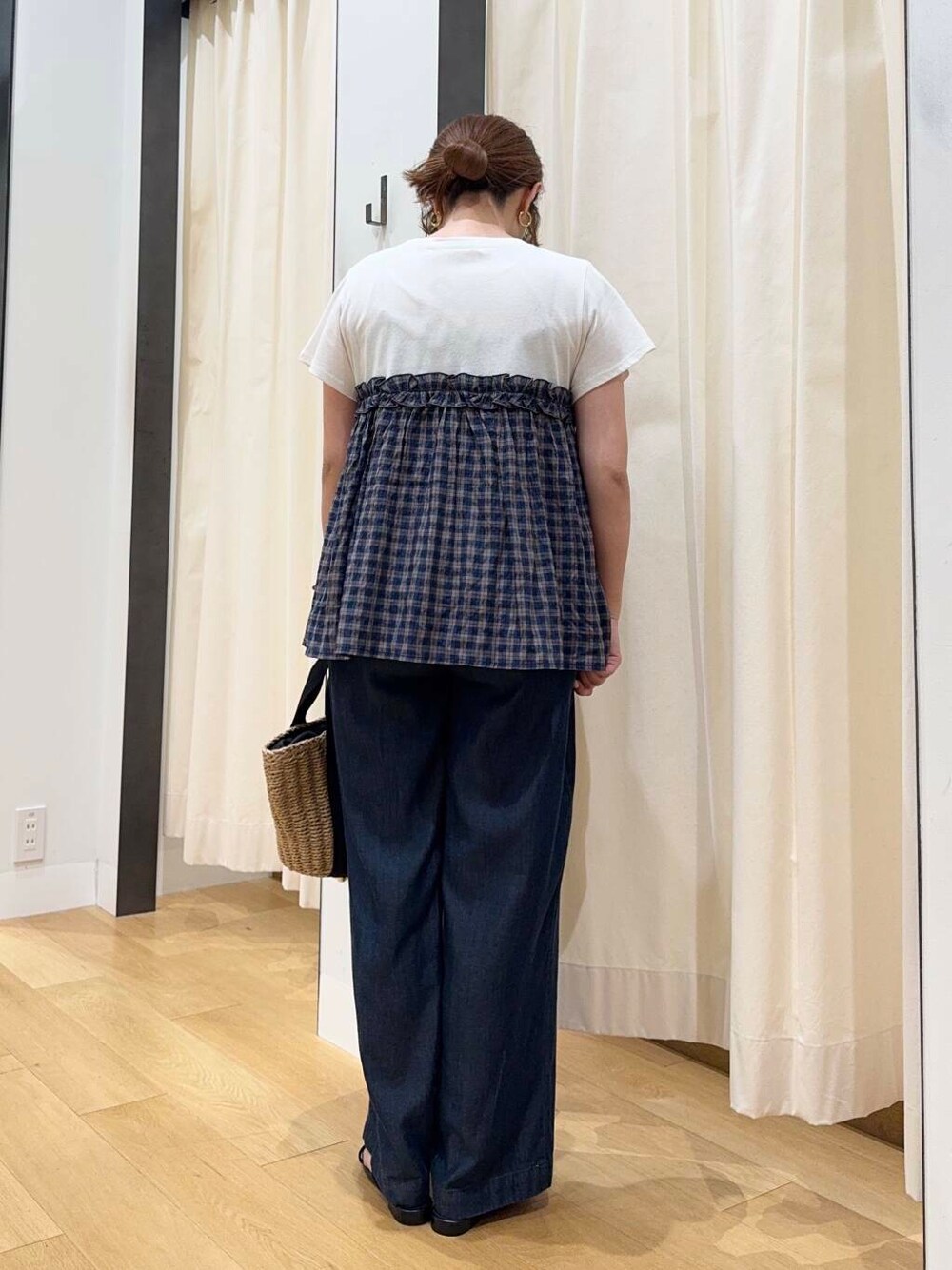 ベージュ系のハンドバッグ、ブルー系のデニムパンツ、ブラック系のサンダルを着用したレディースの夏コーディネートの4枚目の写真