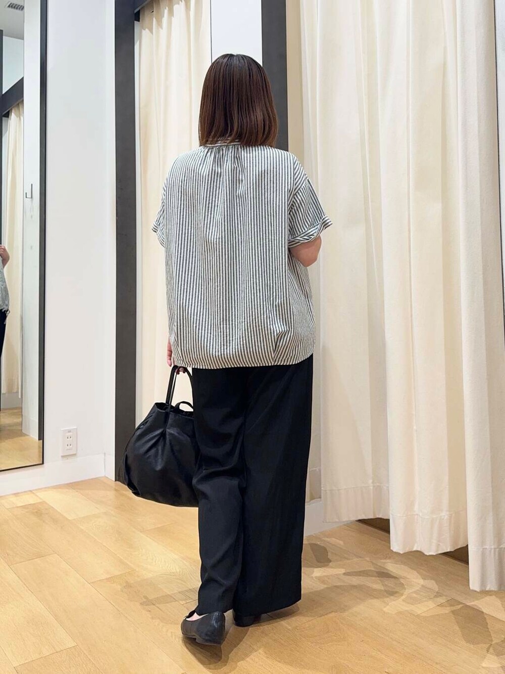 ブラック系のトートバッグ、ブラック系のその他パンツ、ブラック系のローファーを着用したレディースの夏コーディネートの4枚目の写真