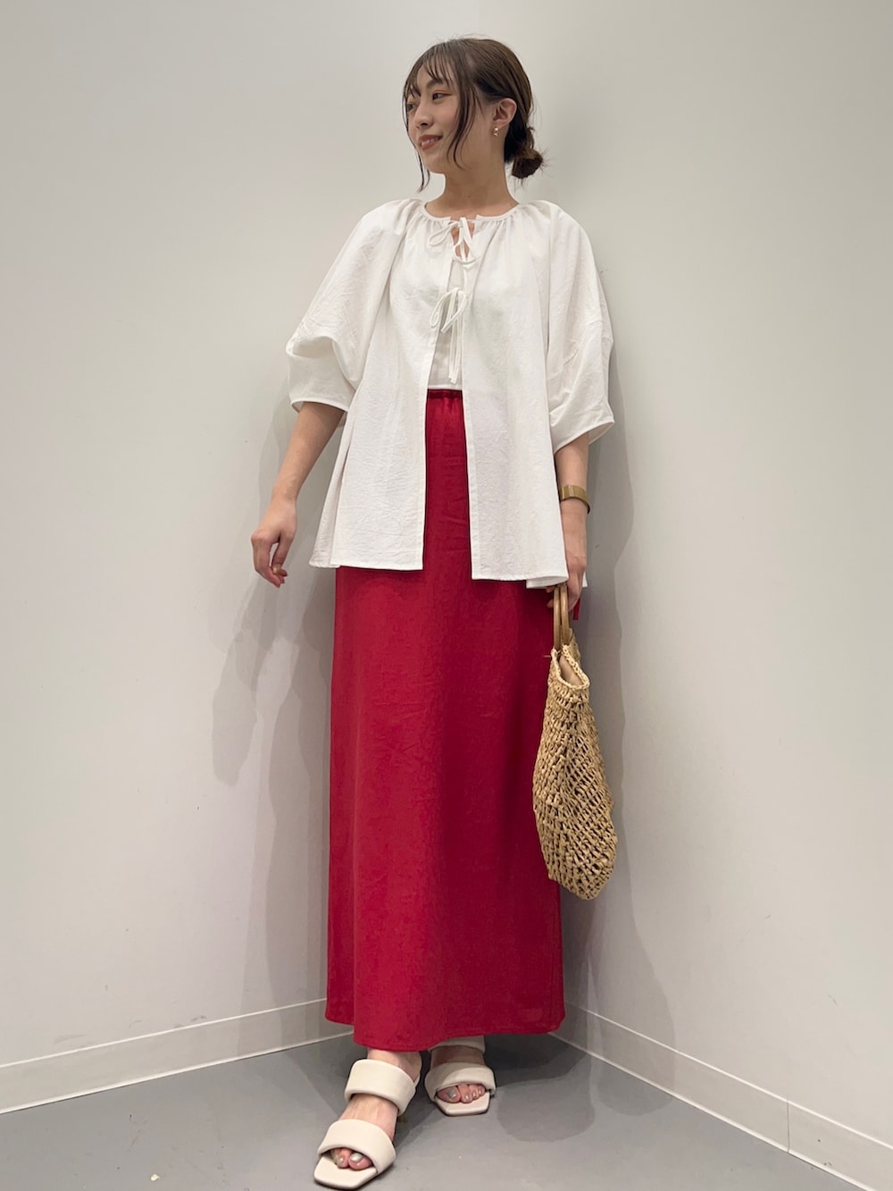 ホワイト系のシャツ/ブラウス、レッド系のスカート、ホワイト系のサンダルを着用したレディースの夏コーディネートの5枚目の写真