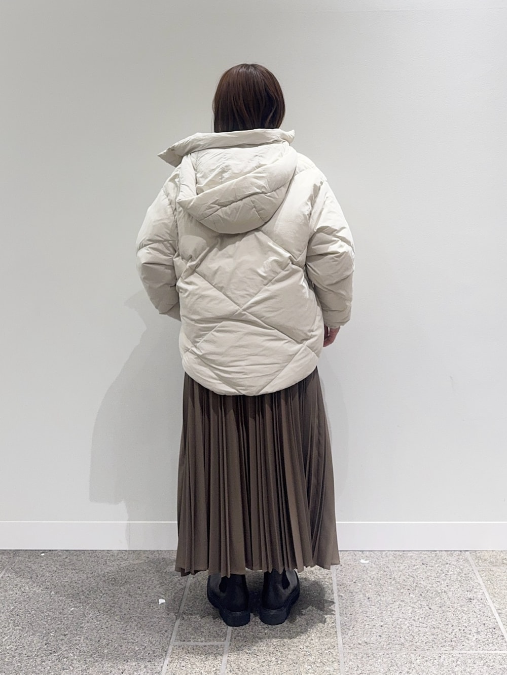 ホワイト系のダウンジャケット/コート、ホワイト系のニット/セーター、ベージュ系のスカートを着用したレディースの冬コーディネートの4枚目の写真