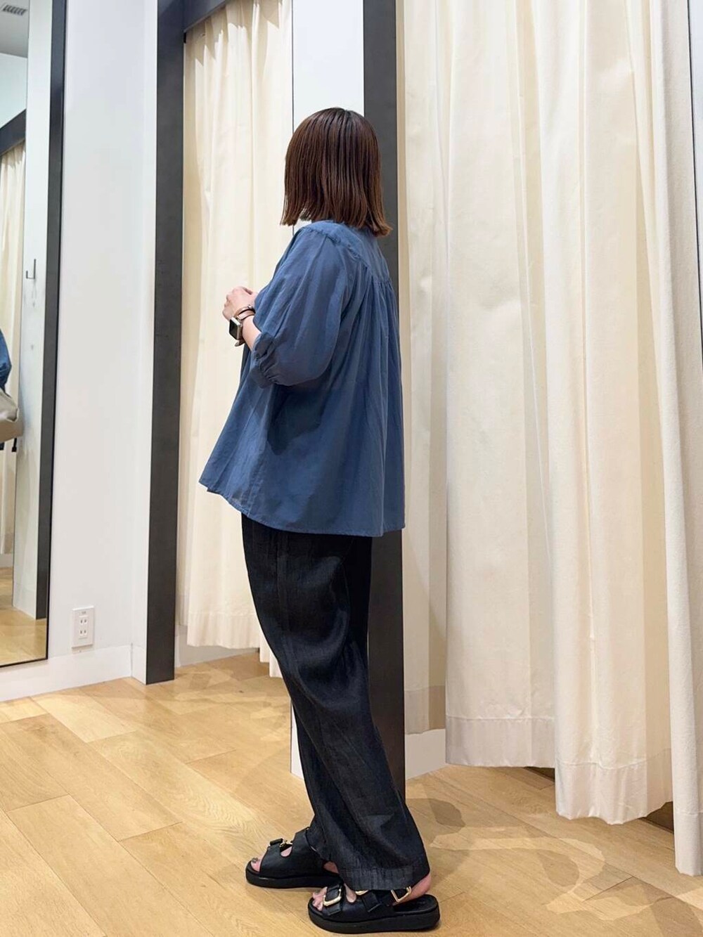 ベージュ系のショルダーバッグ、ブラック系のサンダル、ブラック系のデニムパンツを着用したレディースの夏コーディネートの3枚目の写真